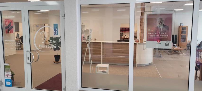 Empfangsbereich mit Schreibtisch, Stühlen und Dekoration in modernem Raum.